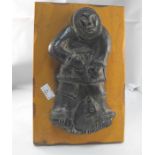 An Inuit carving depicting a figure hunting a seal 18cm high
