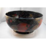 A Moorcroft pottery bowl, decorated pomegranates and grapes (chip to rim) 21cm diameter