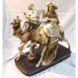 A large Victorian Royal Dux style figural group of two Arab figures riding camels (indistinct makers