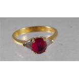 An 18ct gold ring with large central ruby flanked by two triangular cut diamonds