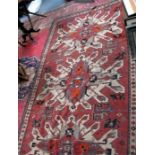 A Caucasian rug, the central panel decorated with three repeating geometic medallions within a