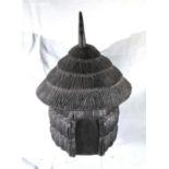 An African carved hardwood lidded box, in the form of a thatched hut 25cm high