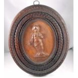 A 17thC Limewood carved panel depicting a small child in a carved wooden frame 22cm x 26cm overall