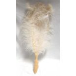 A 19thC ostrich feather fan, with carved ivory handle in the form of a fish, handle 19cm long,