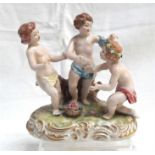 A Continental porcelain group, three semi naked children around a basket of flowers 13cm high