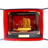 A Korean gilt metal ship in a display case, "The First Armour Clad Ship Kobukson" Condition Report