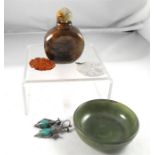 A figured hardstone snuff bottle, a pair of white metal mounted jade earrings, a jade pendant and