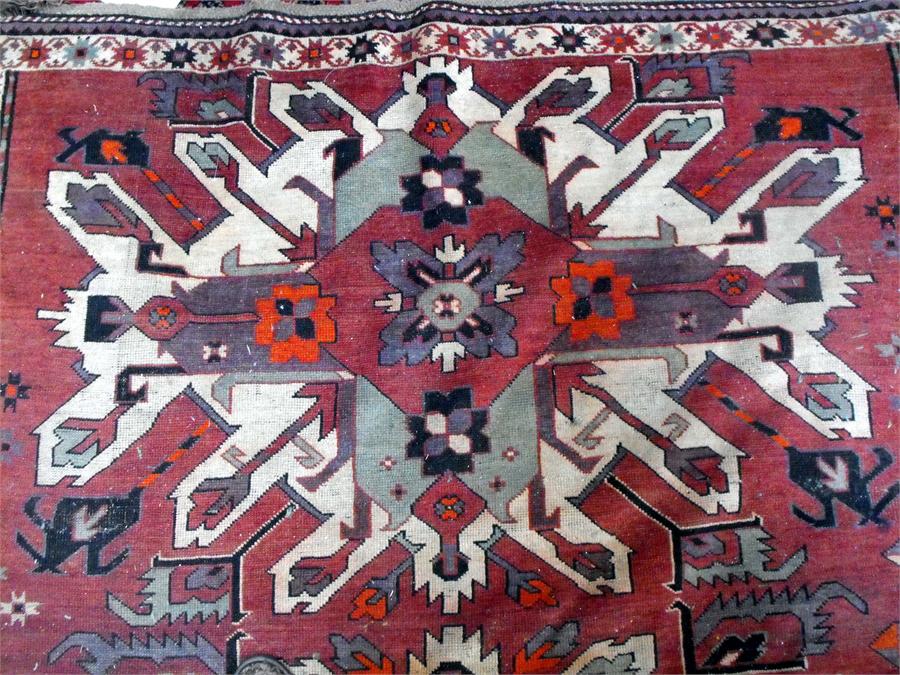 A Caucasian rug, the central panel decorated with three repeating geometic medallions within a - Image 2 of 4