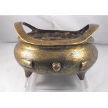 A Chinese late Ming bronze two handled tripod censer decorated with dragons and flowers with
