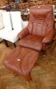 A leather reclining swivel armchair with matching pedestal footstool