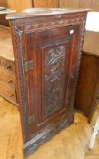 Carved oak corner cupboard, panelled door with floral guilloche decoration,