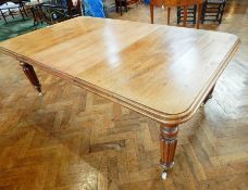 Mahogany extending dining table on reeded and tapering legs and castors,