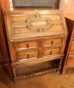 20th century Jacobean-style oak bureau with panelled fall, enclosing fitted interior,