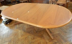 A G-Plan style oak extending dining table, with rounded ends, with right angle splayed supports,