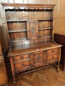 18th century style oak dresser, the open shelf plate rack with central cupboard and lunette carving,