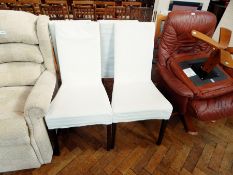 A set of four single chairs with upholstered backs and seats and loose covers,