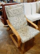 A modern bentwood armchair with floral loose cushions