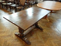 Reproduction oak refectory table on cup and cover supports united by stretchers,