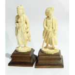 Pair of Japanese ivory figures of a man carrying a gun and a woman carrying a duck,