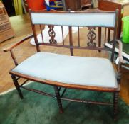 A late Victorian twin seat, with upholstered back panel, pierced fretwork splats,