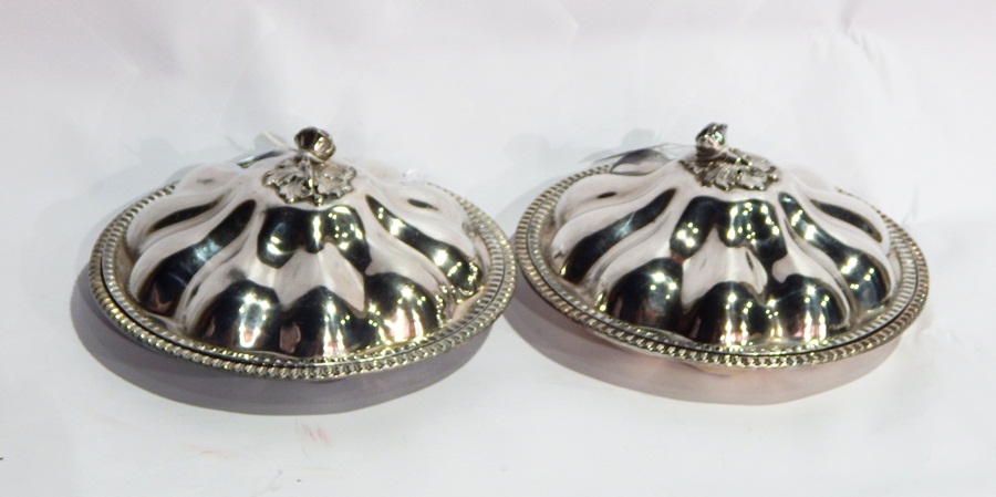 A pair of silver plated entree dishes and covers, with cast floral finials and reeded borders, dia.