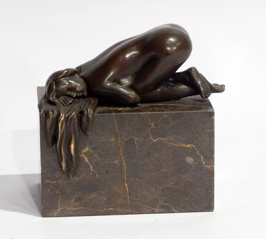 Bronze model of a nude female sleeping in crouched position, raised on rectangular marble base,