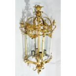 Decorative gilt metal four-light hanging wall lantern of circular form, having four glass panels,