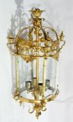 Decorative gilt metal four-light hanging wall lantern of circular form, having four glass panels,