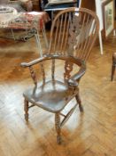 A 19th century high back Windsor armchair, with pierced splat, outswept arms with turned supports,