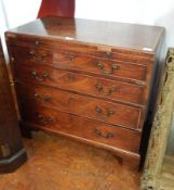 A Georgian mahogany bachelor's chest of four long graduated doors with brushing slide and the