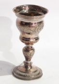 Foreign white metal cup with repousse floral engraving, with baluster stem, on raised circular foot,