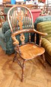 A Windsor stickback elbow chair on turned and tapering supports united by stretchers