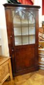 19th century mahogany corner cupboard, the upper lancet glazed section with two shelves,