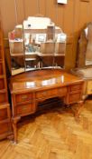 A matching triple mirror back kneehole dressing table, with central frieze drawer,