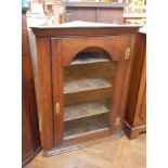 A 19th century oak glazed corner cupboard, the arched panel door enclosing three shelves,