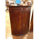 A Georgian mahogany bowfront corner cupboard with inlaid satinwood frieze,