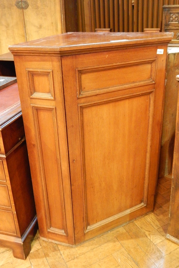 A mahogany corner cupboard, the panel door enclosing three shelves,