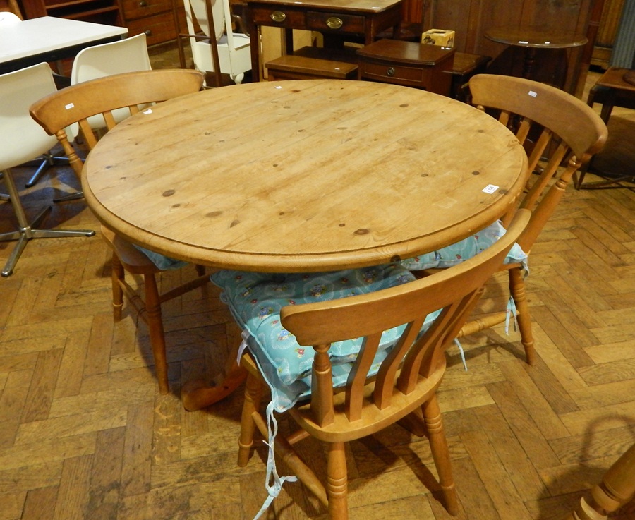 A pine circular top dining table with turned baluster support on quadruped splayed legs,