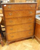 A reproduction walnut veneer chest of five graduated drawers on short cabriole legs,