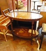 A mahogany oval top two tier tea trolley on turned supports with castors,