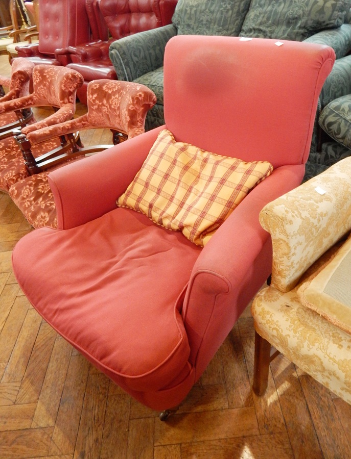 A Victorian red upholstered armchair on square tapering feet with castors