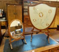 A mahogany framed shield shaped firescreen, with floral silkwork embroidered panel,