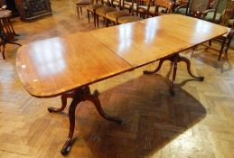 A Georgian style mahogany twin pedestal dining table, with extra leaf,