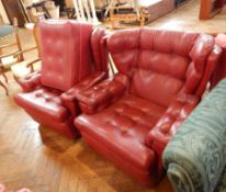 A pair of red leather armchairs and matching footstool