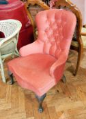 A red upholstered button back chair on cabriole legs and bun feet,