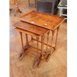 A nest of three burrwood occasional tables, on ring turned column supports,