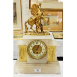 A hardstone mantel clock with flanking gilded figures and horse and man on top