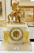 A hardstone mantel clock with flanking gilded figures and horse and man on top