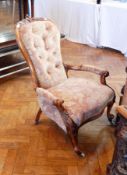 A Victorian carved walnut frame armchair, with foliate carving, button back,