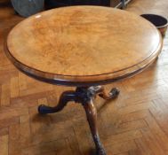 A walnut circular tilt-top table on turned baluster support and cabriole legs